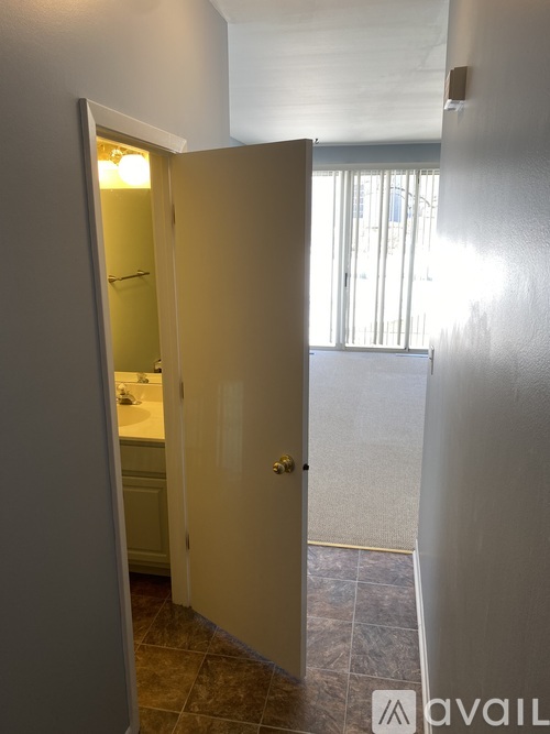 A bathroom with a toilet and sink is visible through an open door.