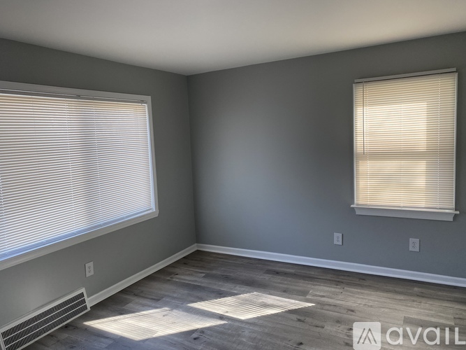 A room with a window and a heater on the floor.