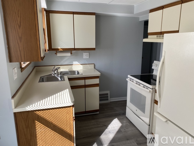 A kitchen with wooden cabinets and a white refrigerator.