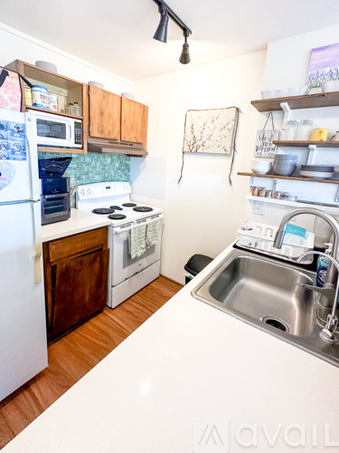 A kitchen with a white counter top and a white fridge.