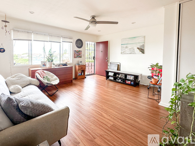 A living room with a grey couch and a wooden floor.