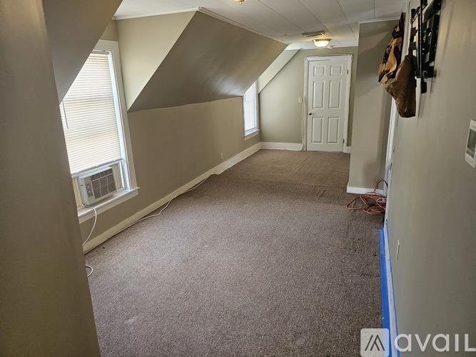 A room with a carpeted floor and a white door.