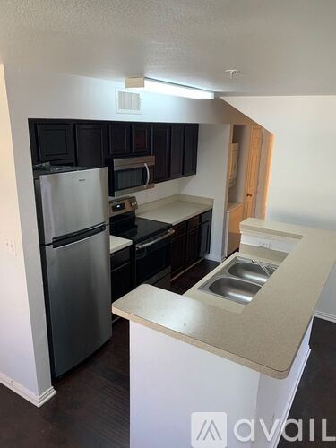 A kitchen with a white counter top and stainless steel appliances.