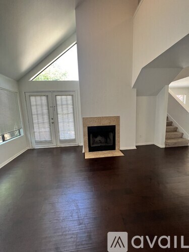 A living room with a fireplace and a staircase.