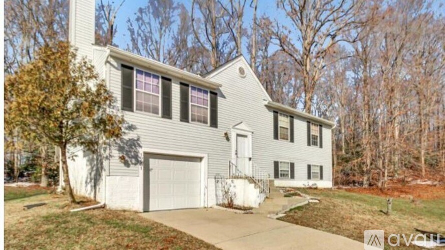 A house with a grey siding and a white garage door.