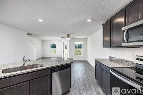 A kitchen with dark wood cabinets and granite countertops.