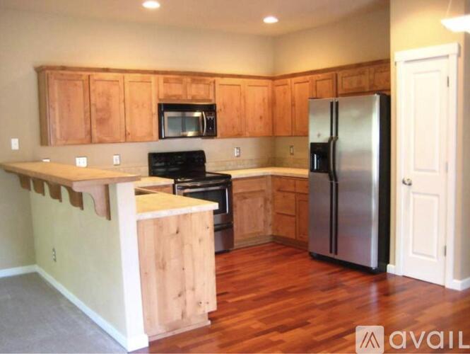 A kitchen with wooden cabinets and a refrigerator.