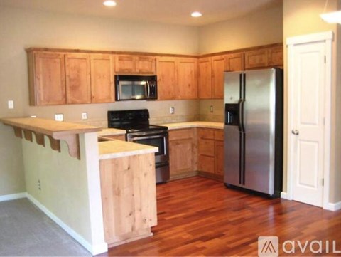 A kitchen with wooden cabinets and a refrigerator.