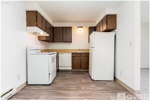 A kitchen with white appliances and wooden cabinets.