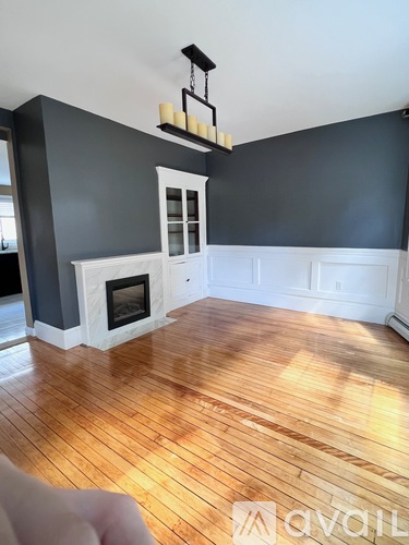 A room with a fireplace and wooden floors.