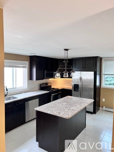 A kitchen with a granite countertop and stainless steel appliances.