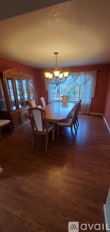 A dining room with a wooden table and chairs.