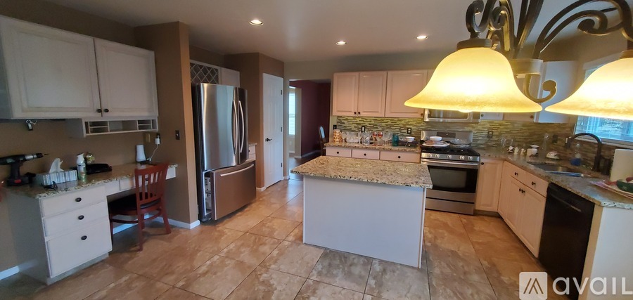 A kitchen with a refrigerator, stove, and oven.