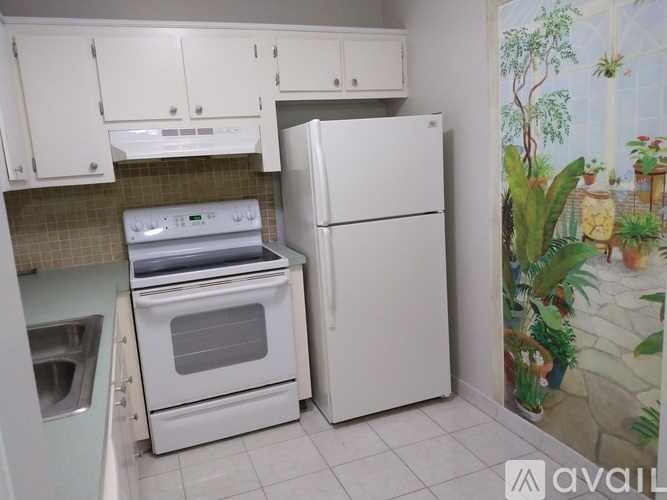 A white kitchen with a white fridge and a white stove.