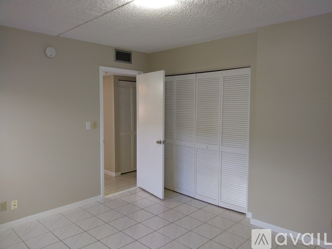 A room with a white door and white closet doors.