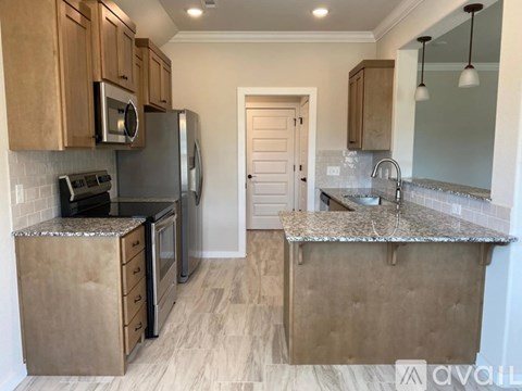 A kitchen with wooden cabinets and a granite countertop.