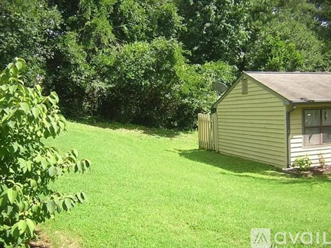 A small house with a green lawn in front of it.