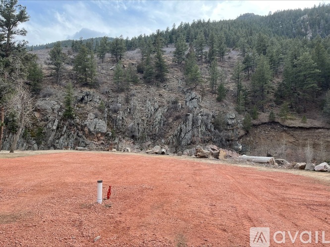A red dirt field with a white post in the middle and a mountain in the background.