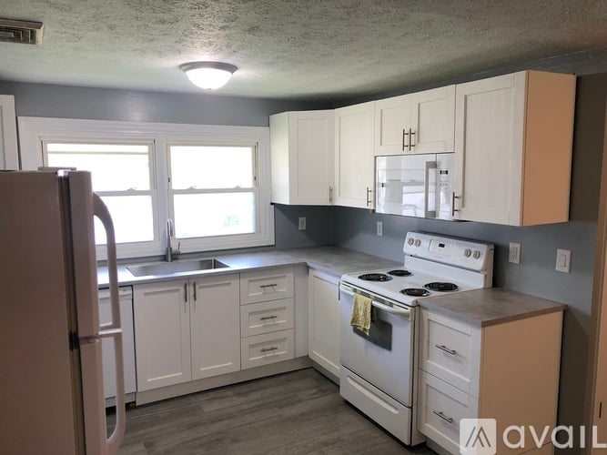 A kitchen with white cabinets and appliances.