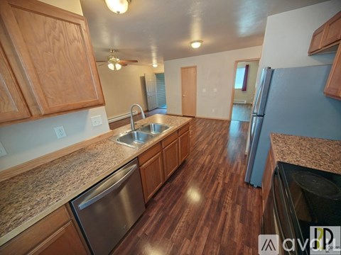A kitchen with wooden cabinets and a granite countertop.