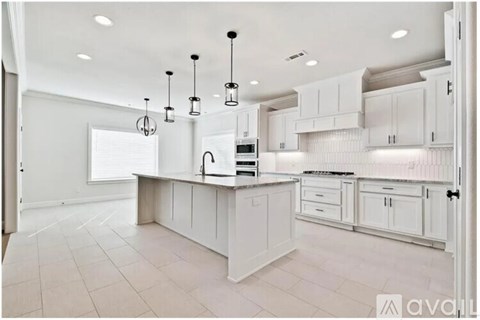 A kitchen with white cabinets and a central island.