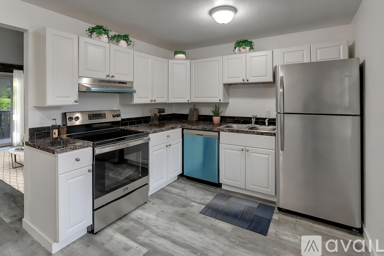 A kitchen with white cabinets and a stainless steel refrigerator.