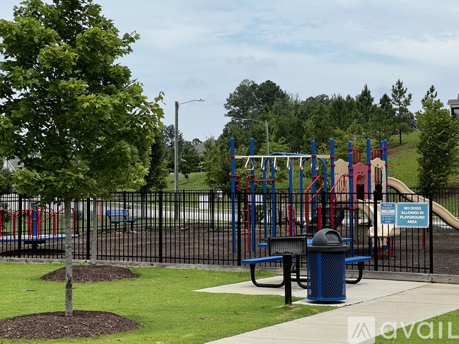 A playground with a blue trash can and a sign that says "No Climbing".