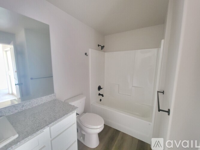 A white bathroom with a toilet, sink, and bathtub.