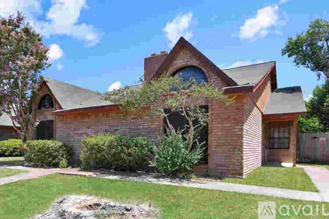 A house with a brown roof and a tree in front of it.