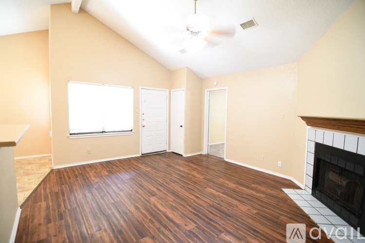 A living room with wood floors and a fireplace.