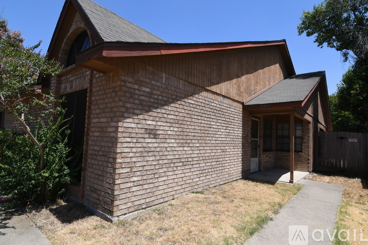 A house with a brown brick exterior and a red roof.