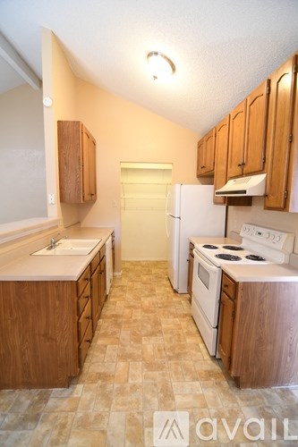 A kitchen with wooden cabinets and a tiled floor.