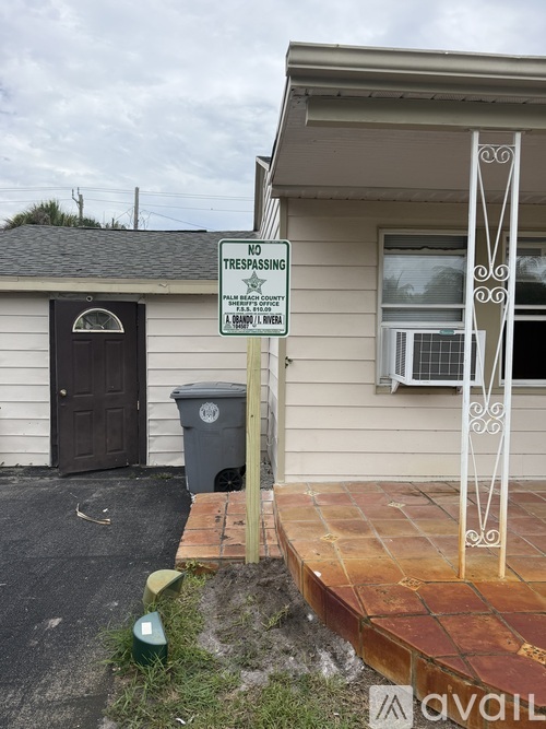 A sign on a pole in front of a house states "NO TRESPASSING".