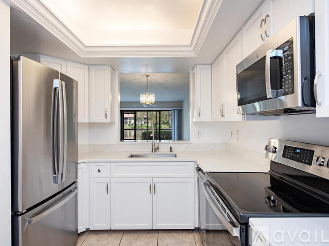 A kitchen with white cabinets and stainless steel appliances.