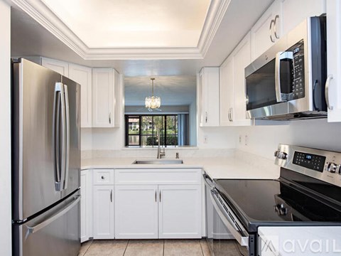 A kitchen with white cabinets and stainless steel appliances.