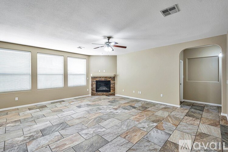 A spacious room with a stone floor and a fireplace.