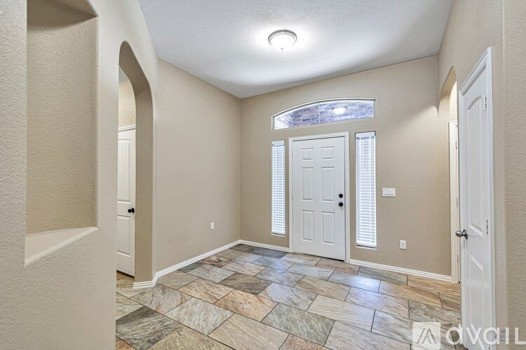 A hallway with a stone floor and white doors.