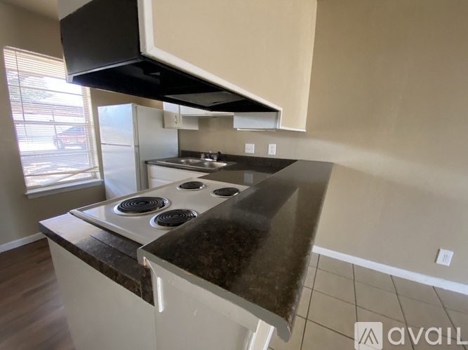 A kitchen with a black stove top and white cabinets.