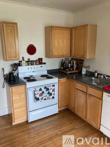A kitchen with wooden cabinets and a white stove top oven.