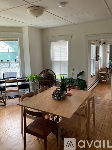 A dining room with a wooden table and chairs.