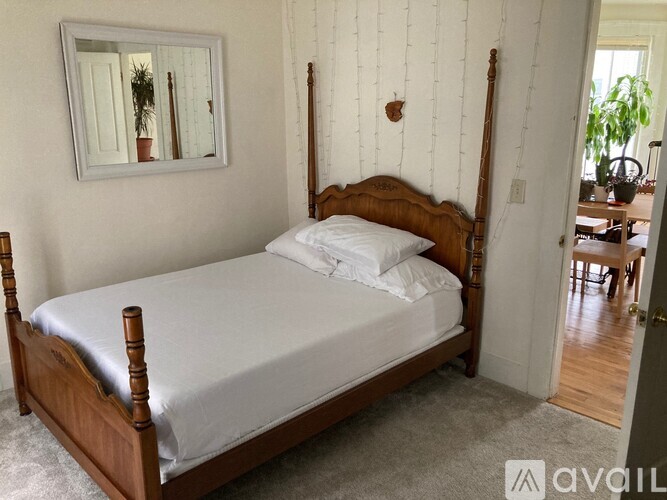 A bed with a white sheet and a wooden headboard.