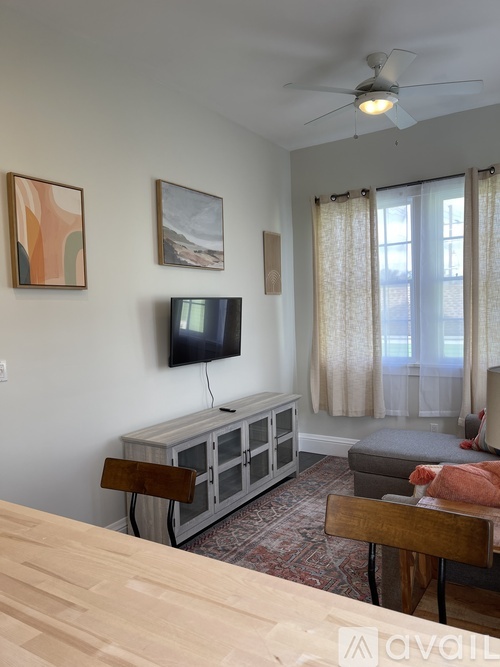 A living room with a television, a couch, and a wooden table.