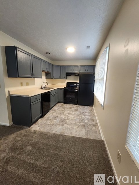 A kitchen with a black oven and cabinets.