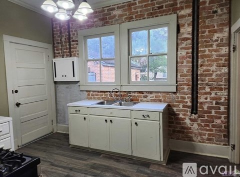 A kitchen with a brick wall and a window.