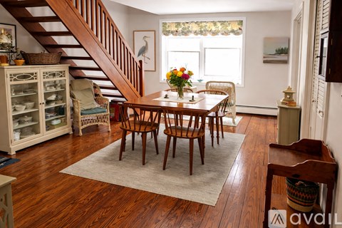 A dining room with a wooden table and chairs.