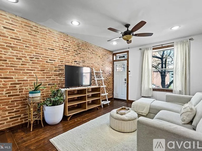 A living room with a brick wall and a flat screen TV.