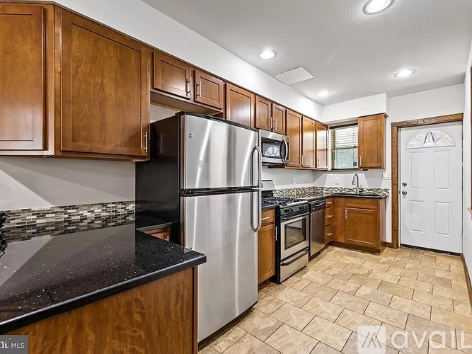 A kitchen with wooden cabinets and a black countertop.
