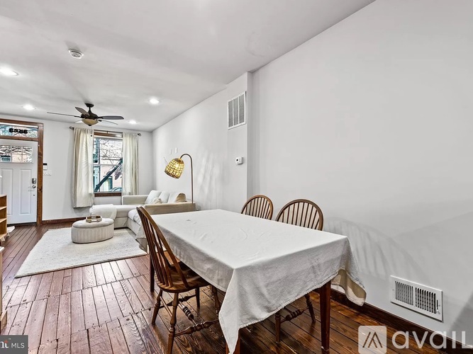 A dining room with a white table and chairs.