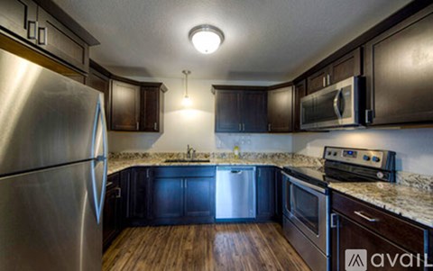A kitchen with dark wood cabinets and stainless steel appliances.