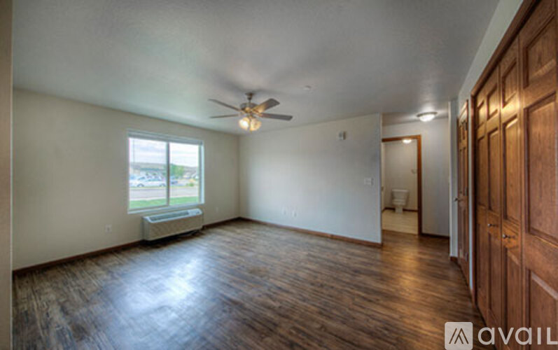 A room with wooden floors and a ceiling fan.